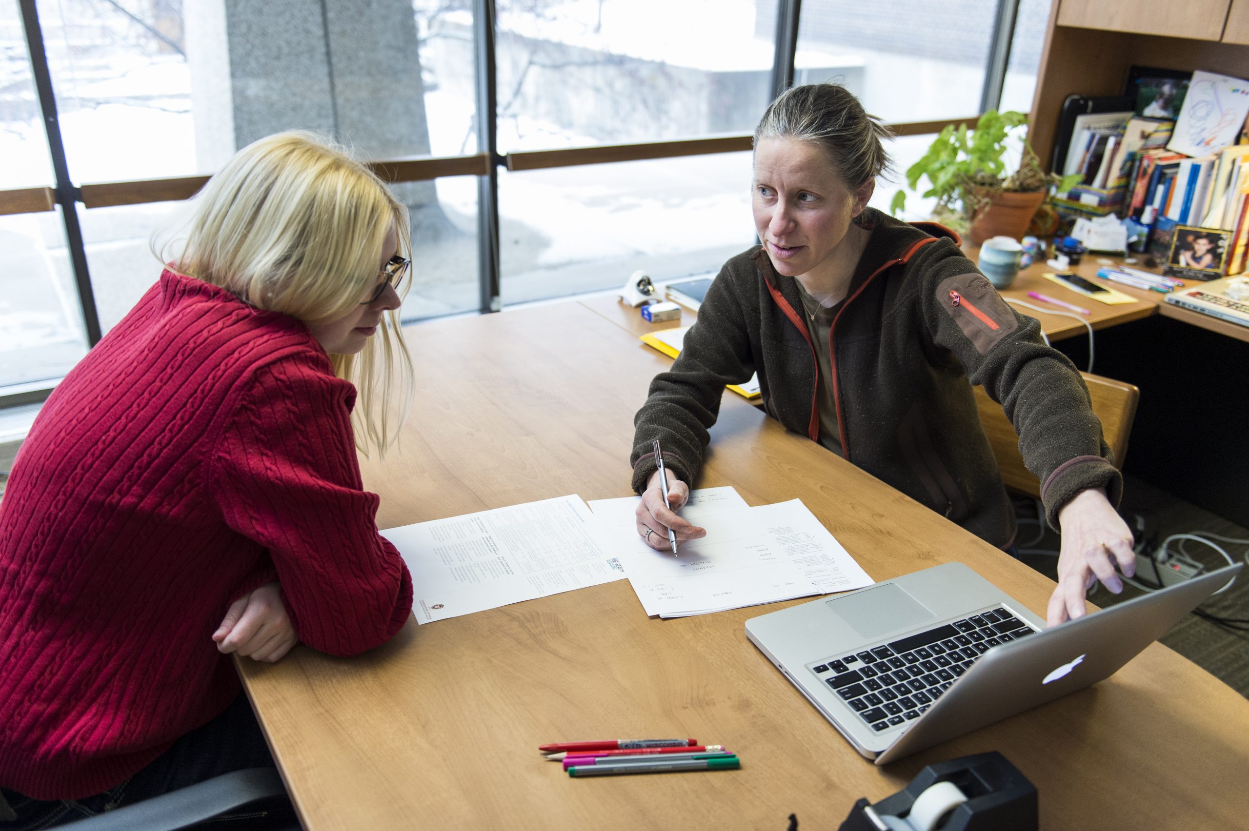 student and professor talking at a table